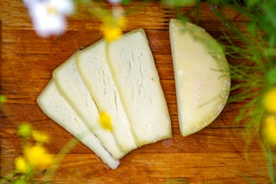 Sliced provolone cheese on a wooden board