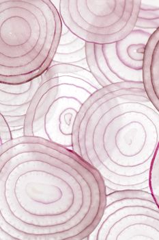 Thinly sliced red onion on a white surface