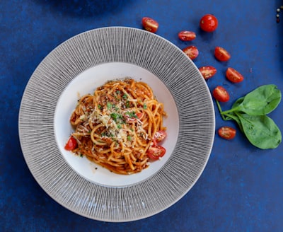 Spaghetti with tomato sauce, cherry tomatoes, and basil