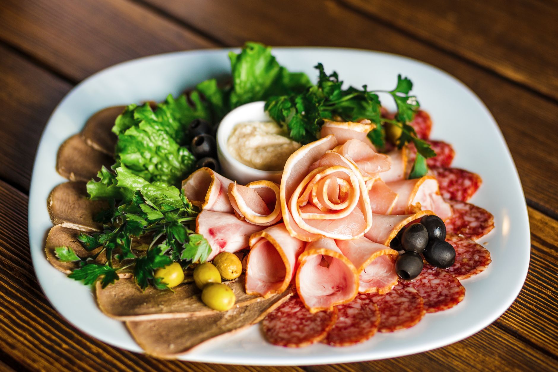 Platter of sliced ham, salami, and olives