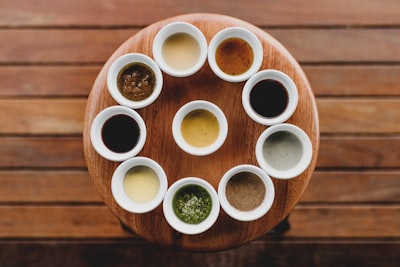 Variety of dipping sauces in cups on a wooden board