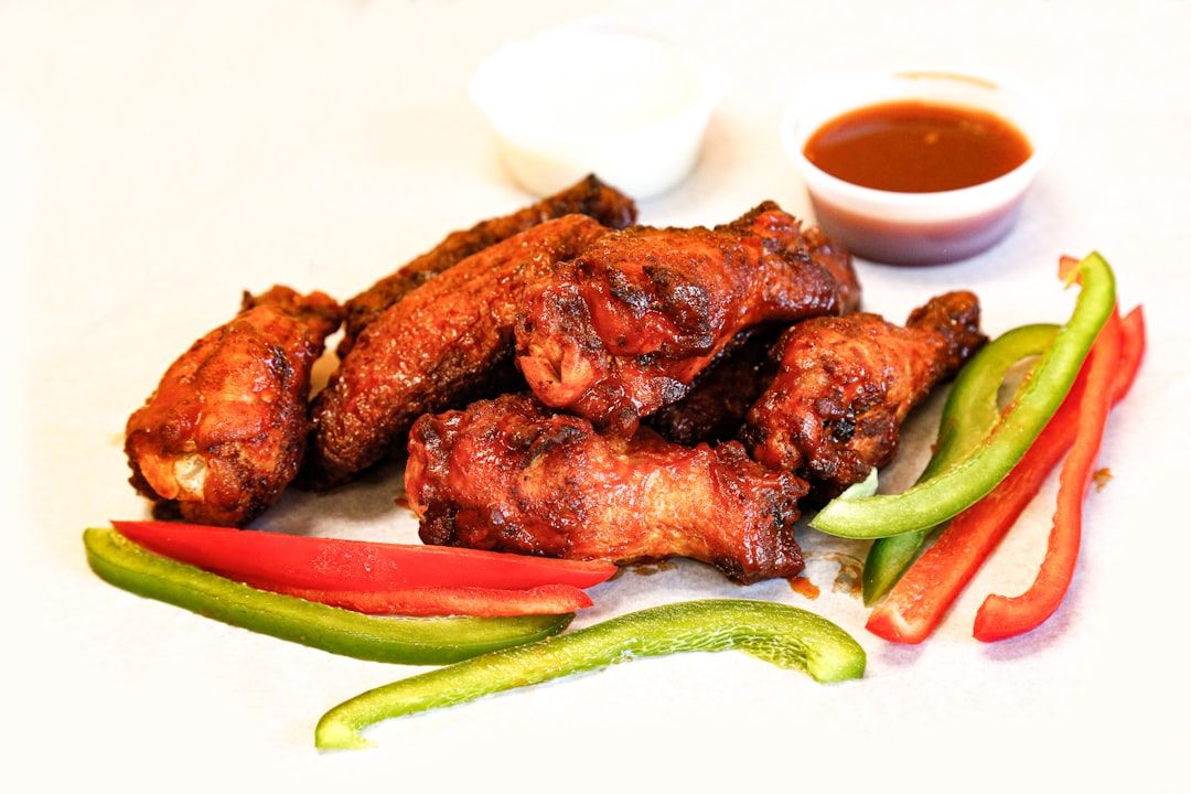 Sauced chicken wings served with peppers on a plate