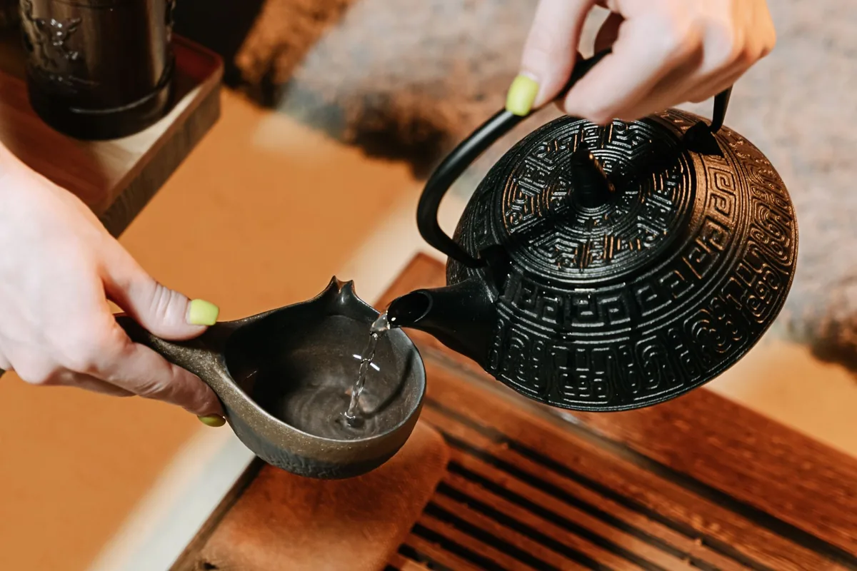 Pouring hot water into a teapot