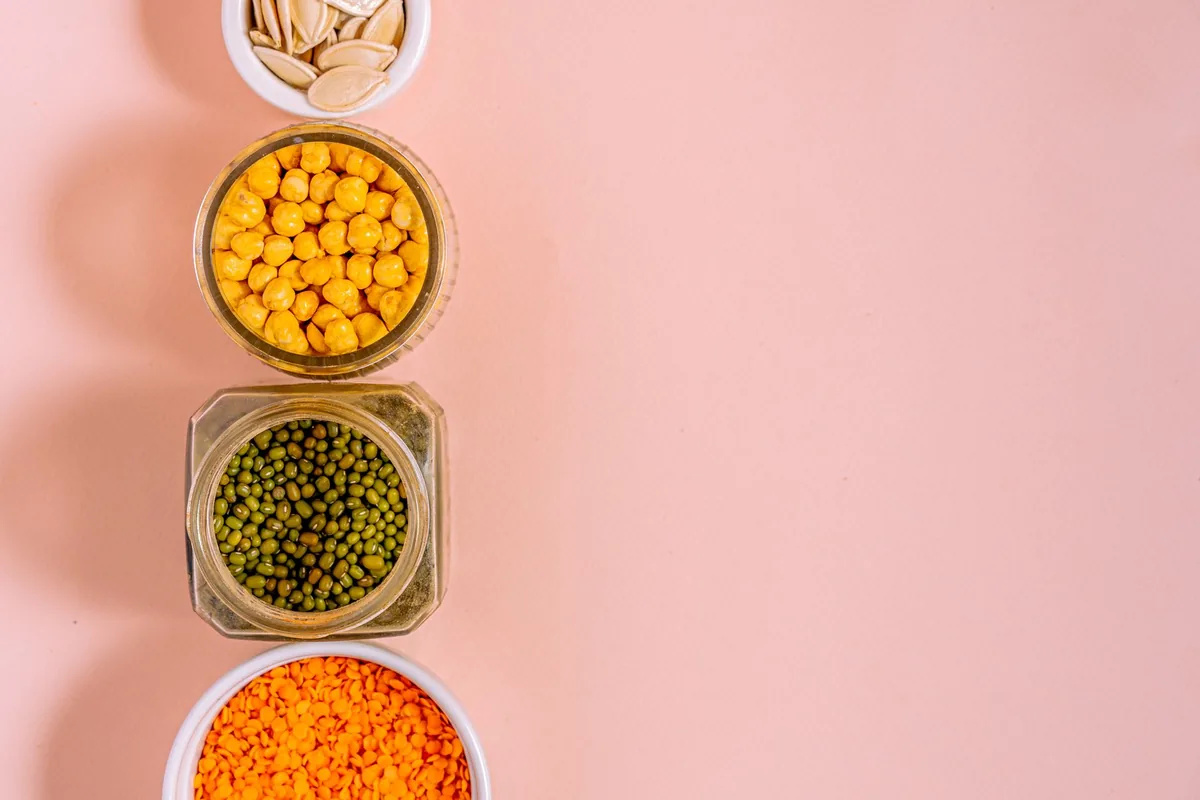 Dried chickpeas, lentils and mung beans in bowls on a counter