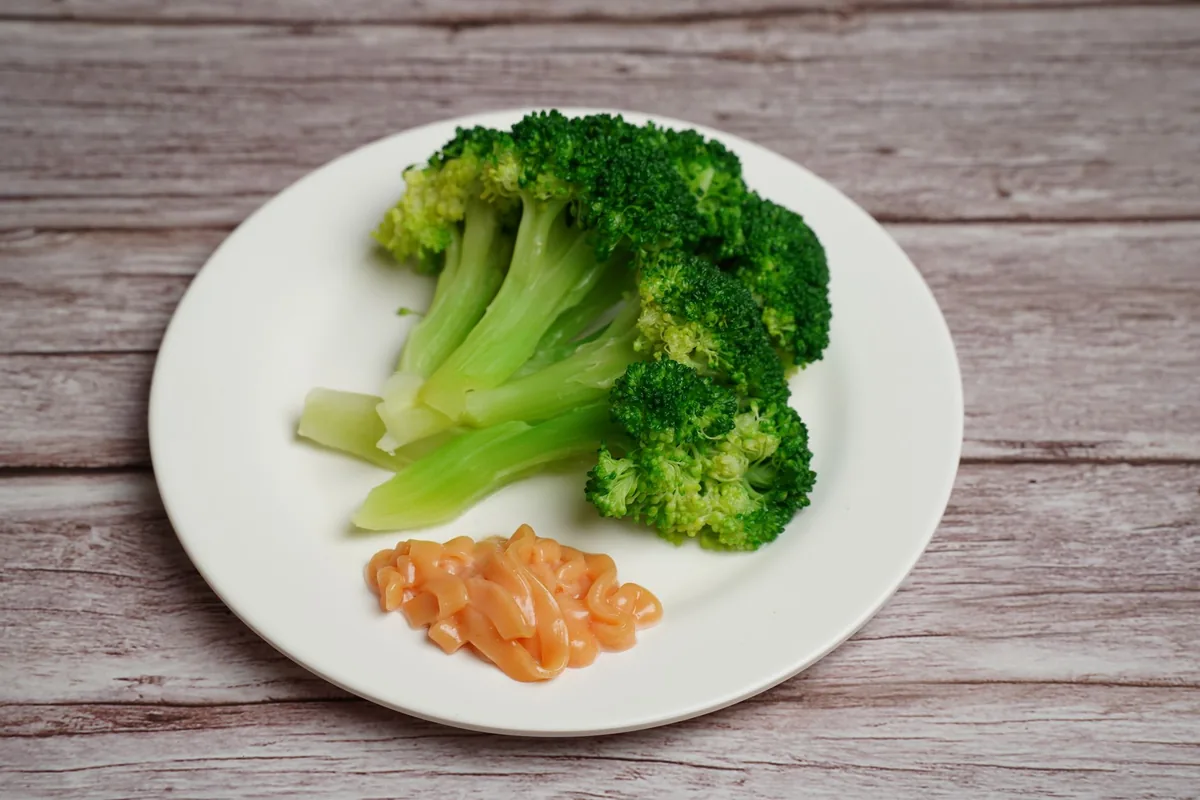 Fresh steamed broccoli served on a white plate