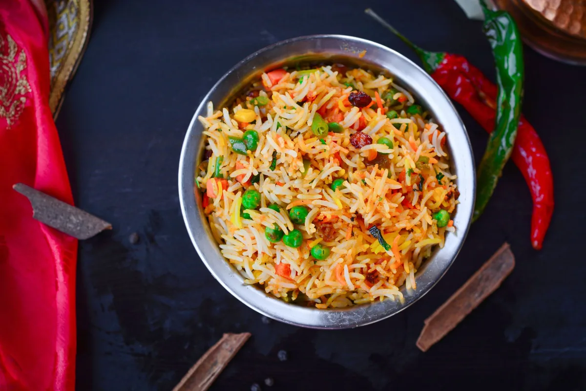 Colourful vegetable biryani in a metal bowl