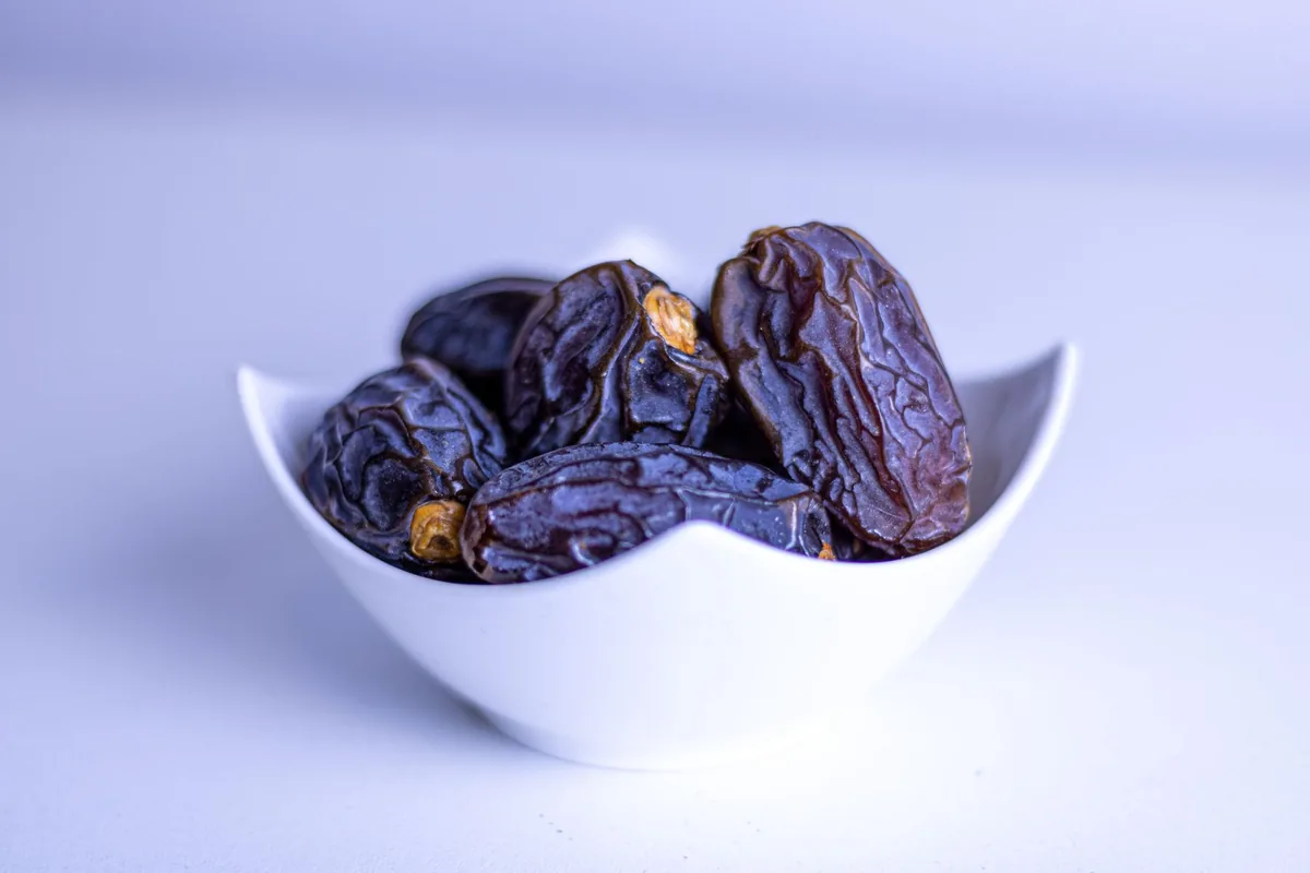 Fresh dates in a decorative white bowl