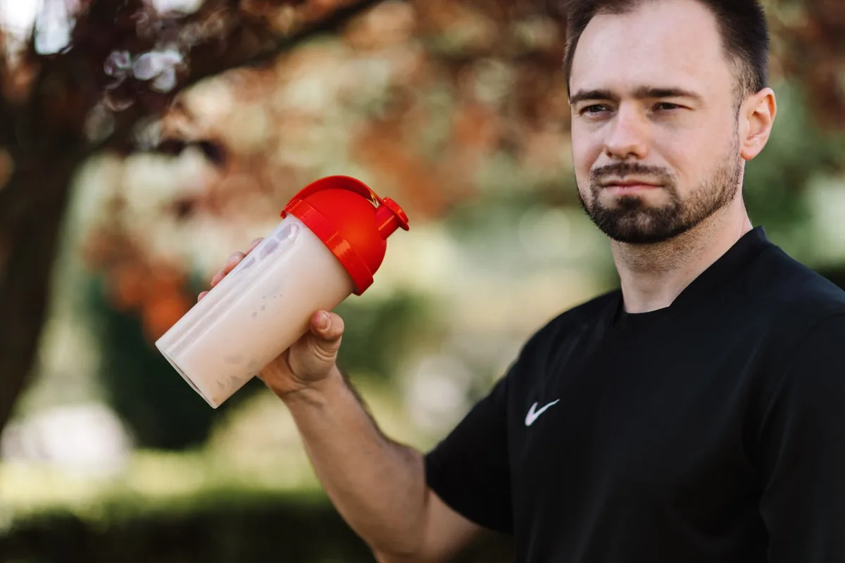 Protein powder beside a shaker bottle
