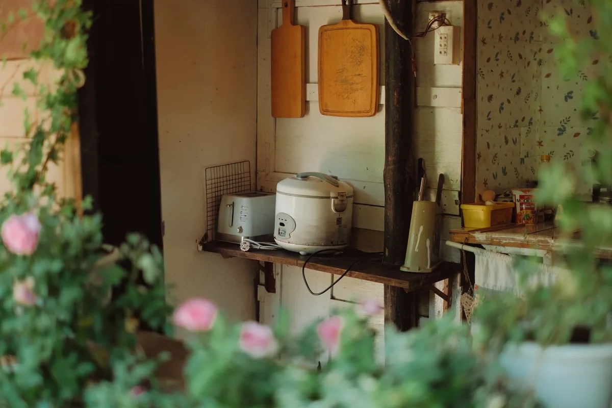 A rice cooker on a rustic kitchen counter