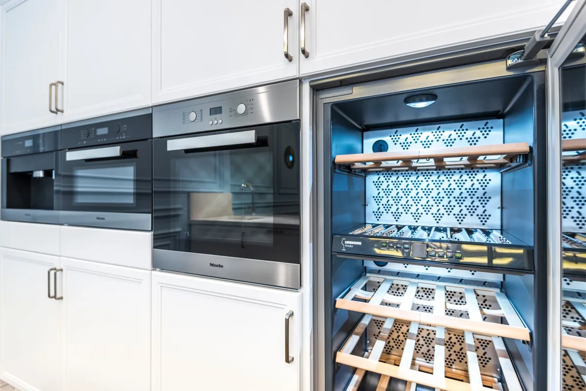 Row of stainless steel kitchen appliances in a showroom