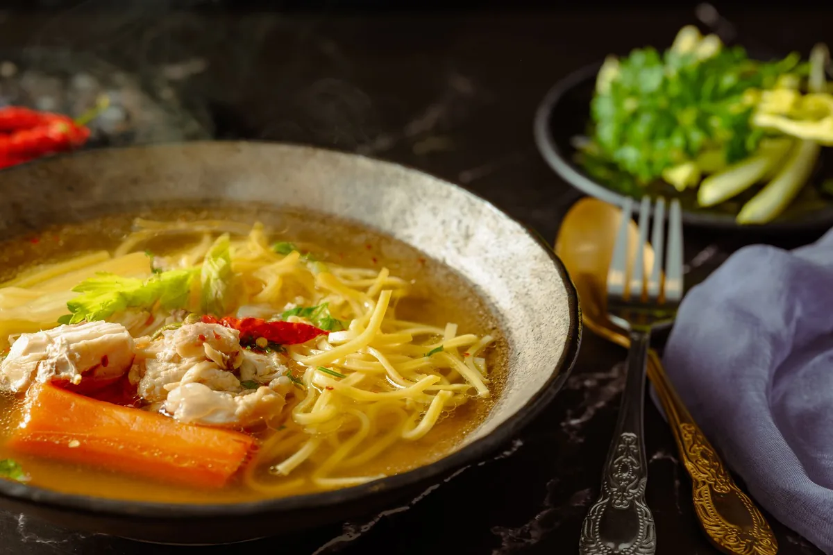 Chicken noodle soup with garnishes in a bowl