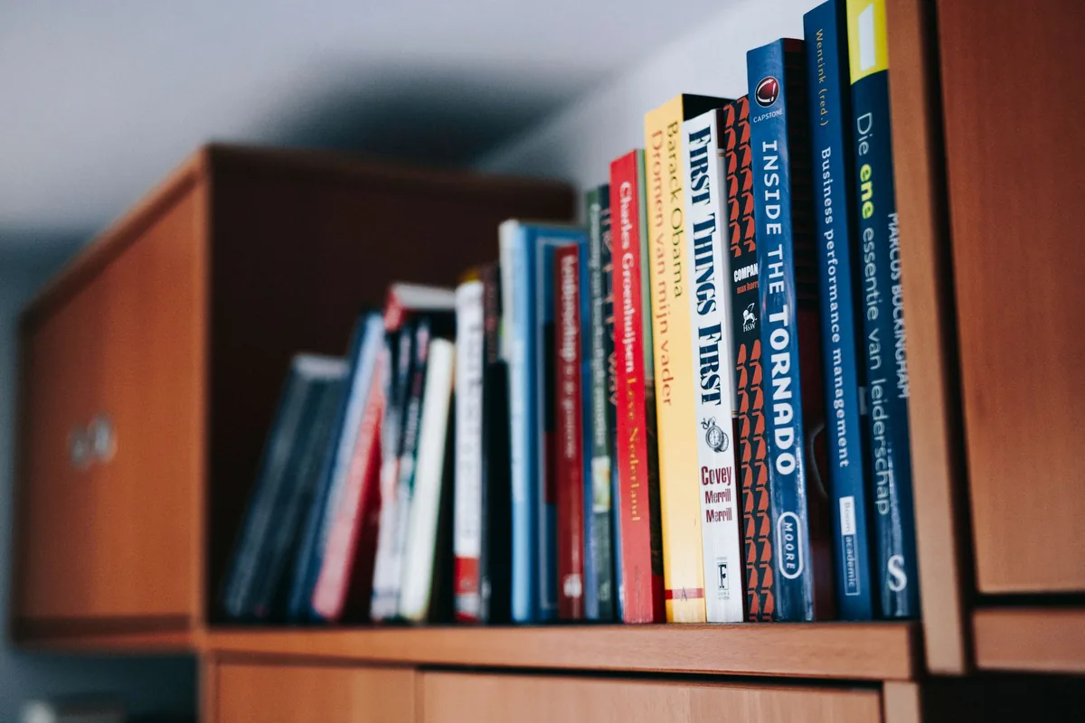 Books neatly arranged on a wooden bookshelf