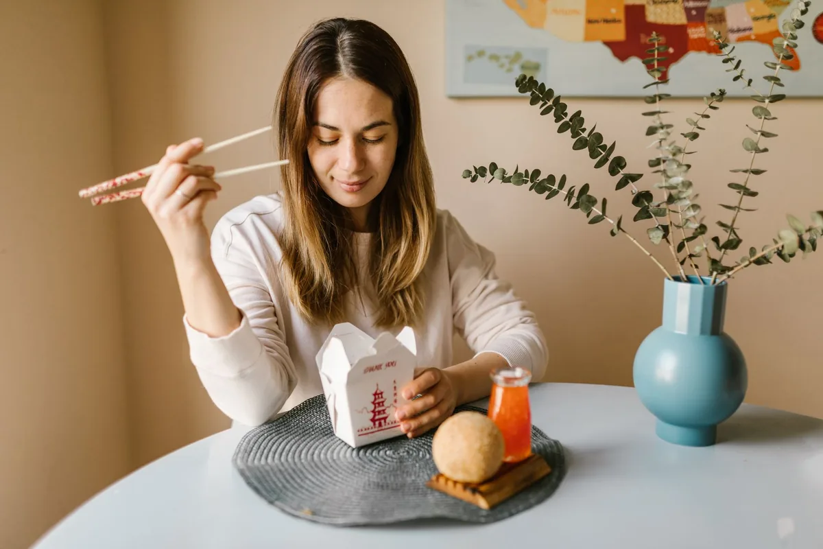 Person eating a takeout-style meal at home