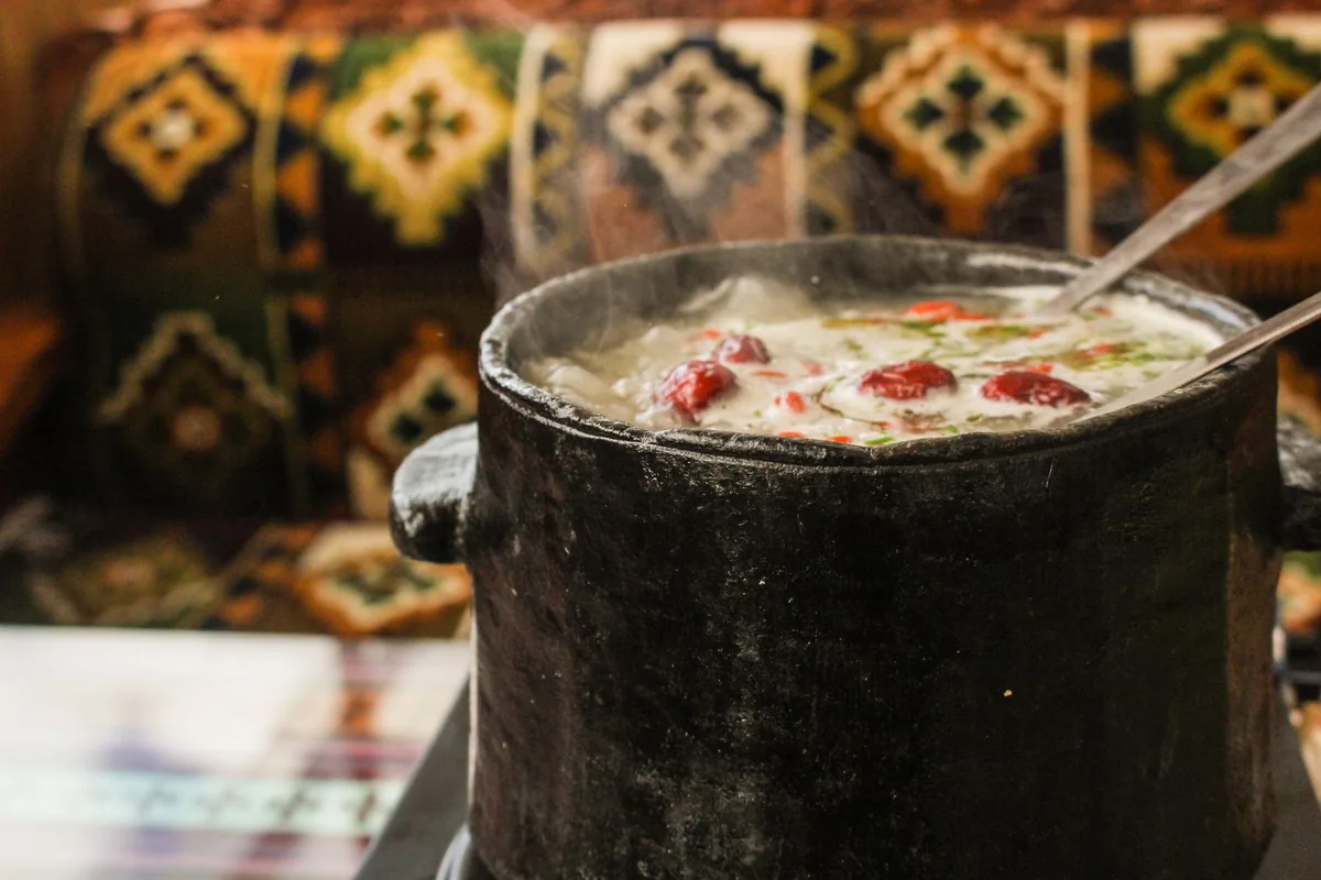 Steaming soup served in a rustic clay pot