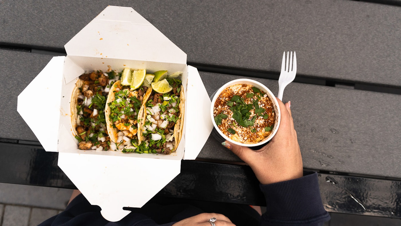 Street-style tacos with lime and cilantro in an open takeout box