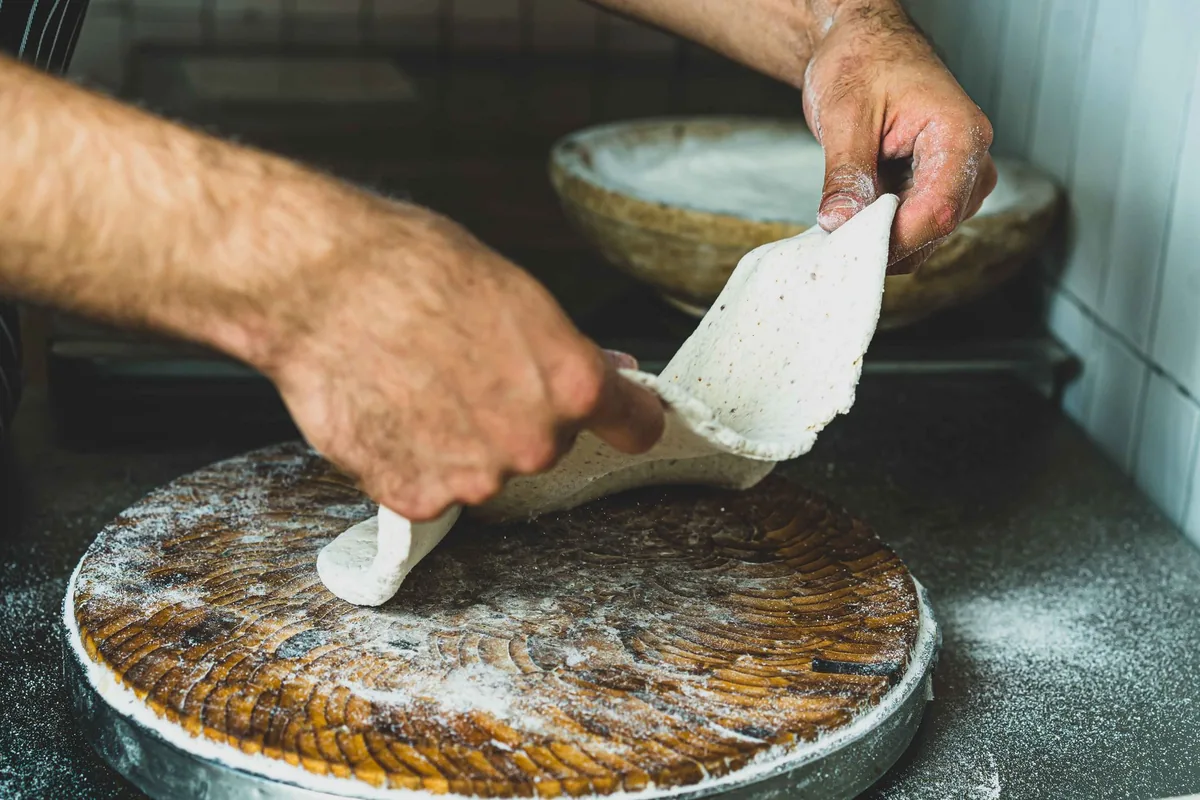 Stretching pizza dough by hand