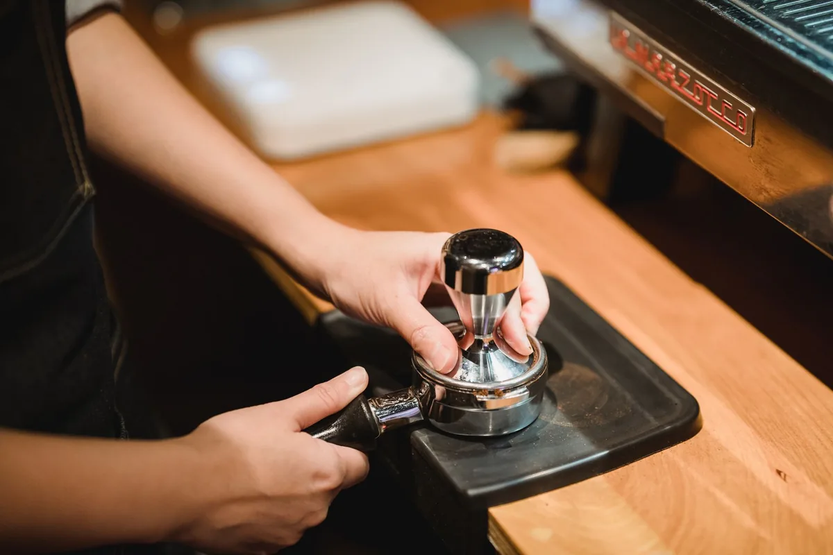 Tamping ground coffee