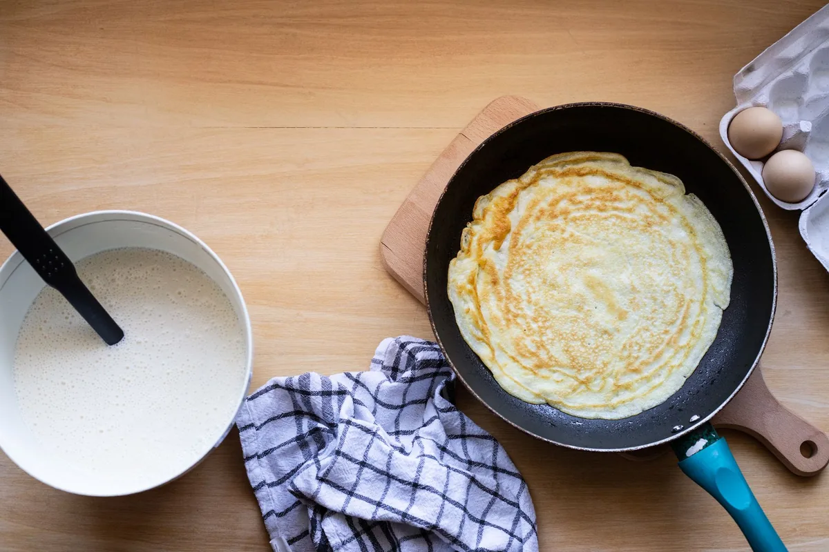 Thin batter spread on a hot plate