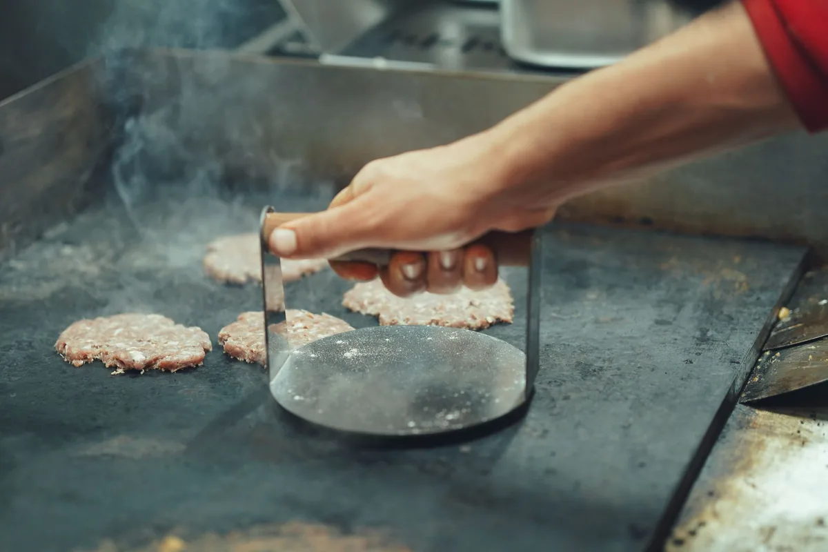 Using a burger press on a hot griddle