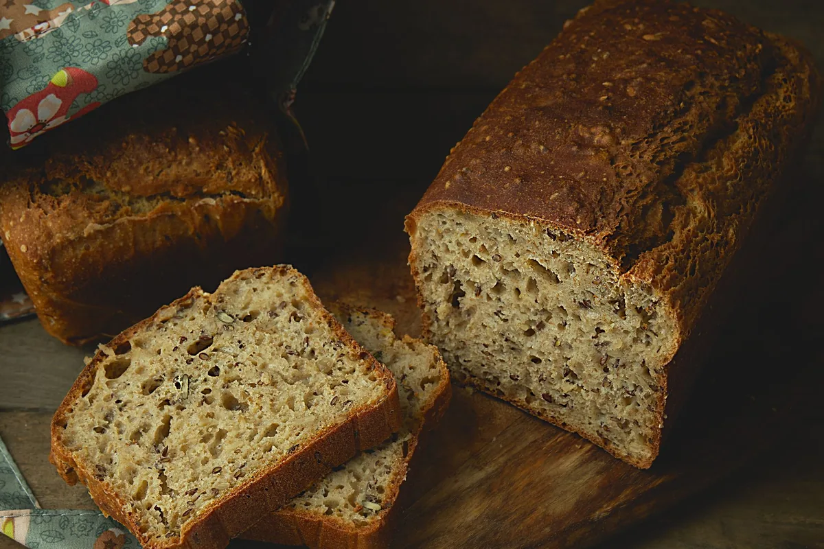 A whole wheat bread loaf with slices