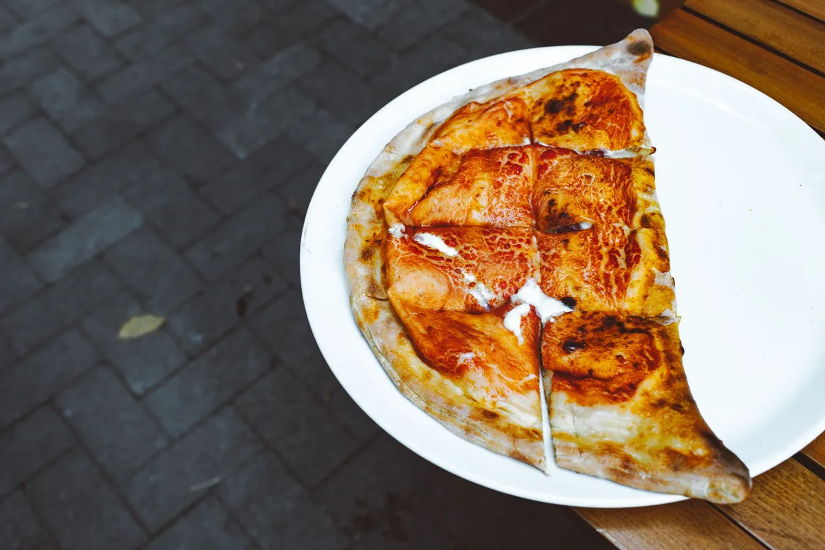 A baked calzone cut open to show melted cheese inside