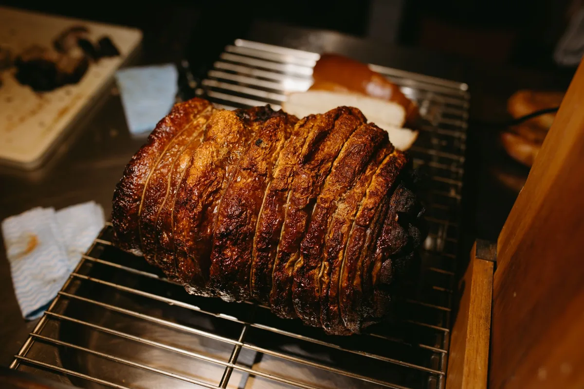 A glazed roast resting on a wire rack