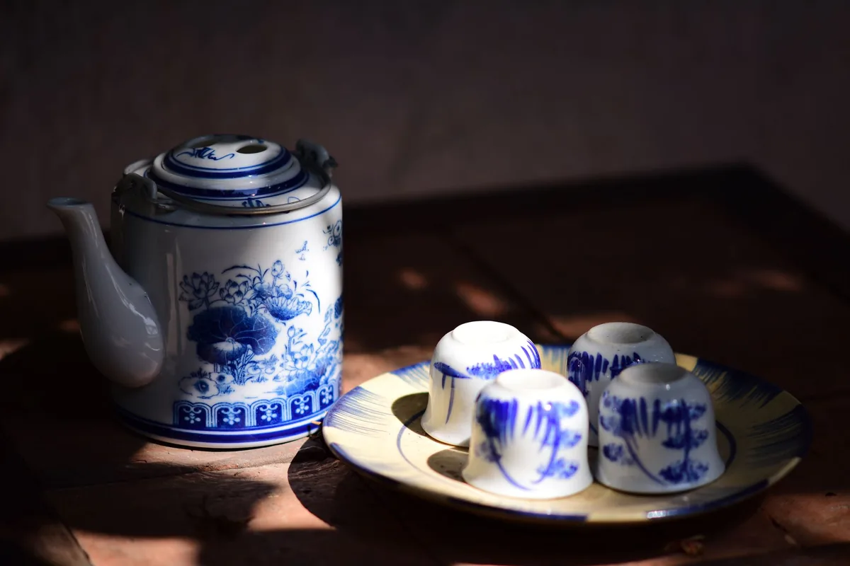 A blue and white teapot with small cups