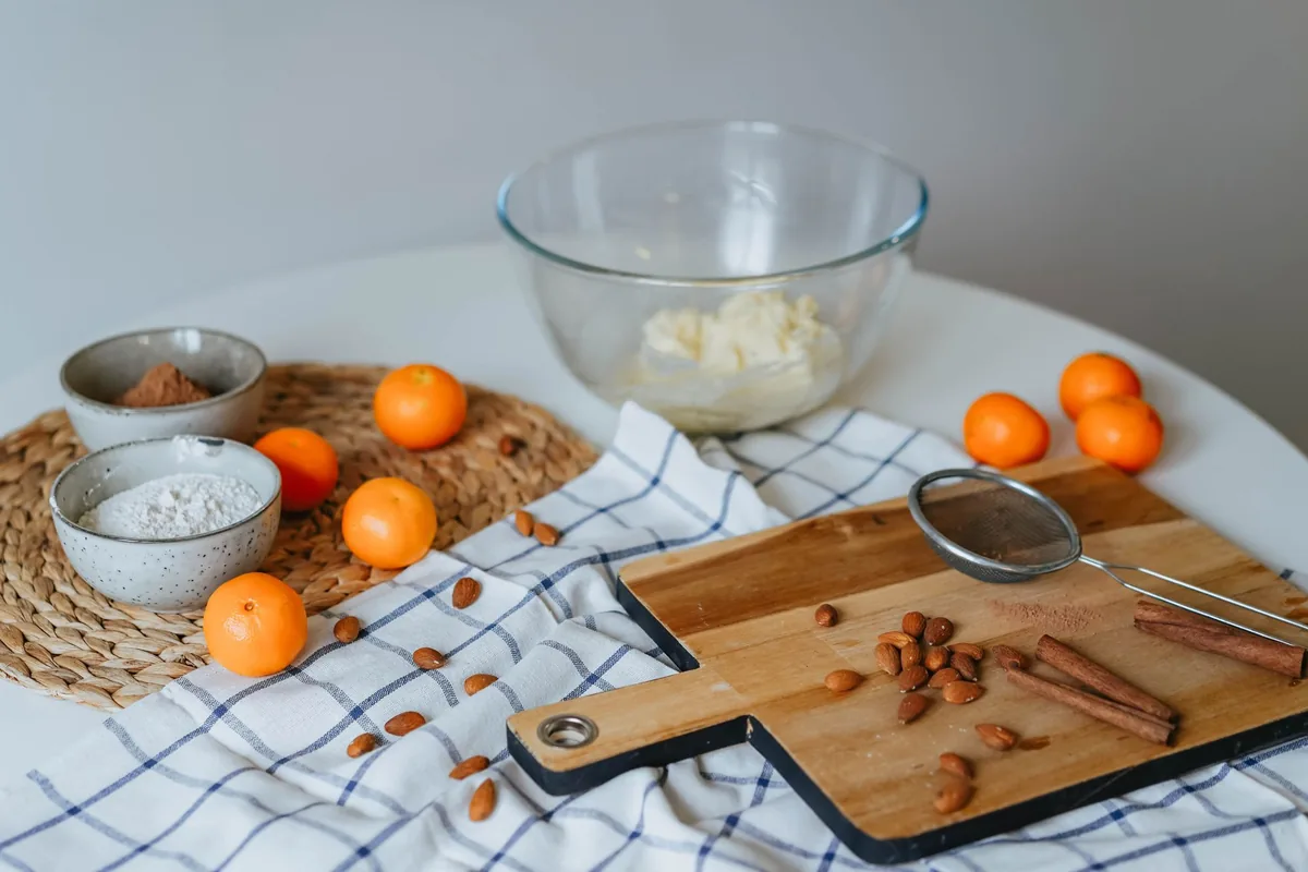 A bowl of fine almond flour next to a small pile of whole almonds
