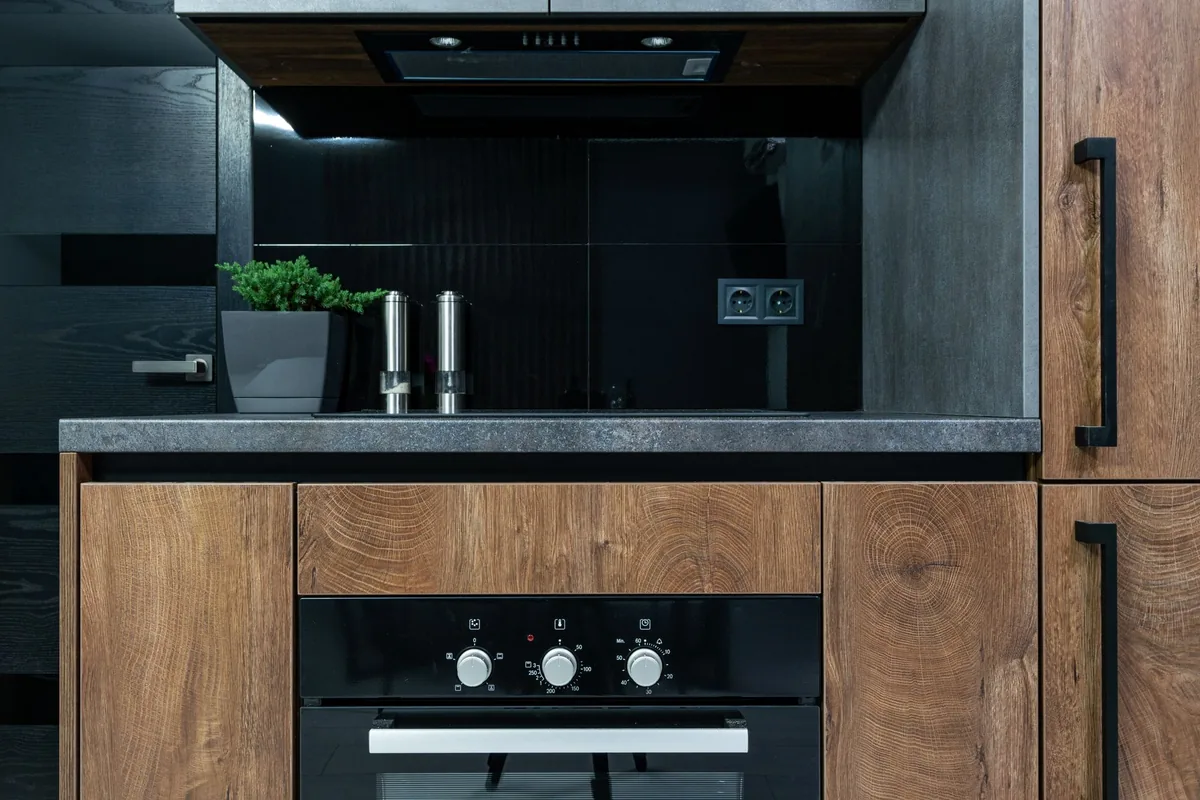 A built-in wall oven beneath a dark kitchen counter
