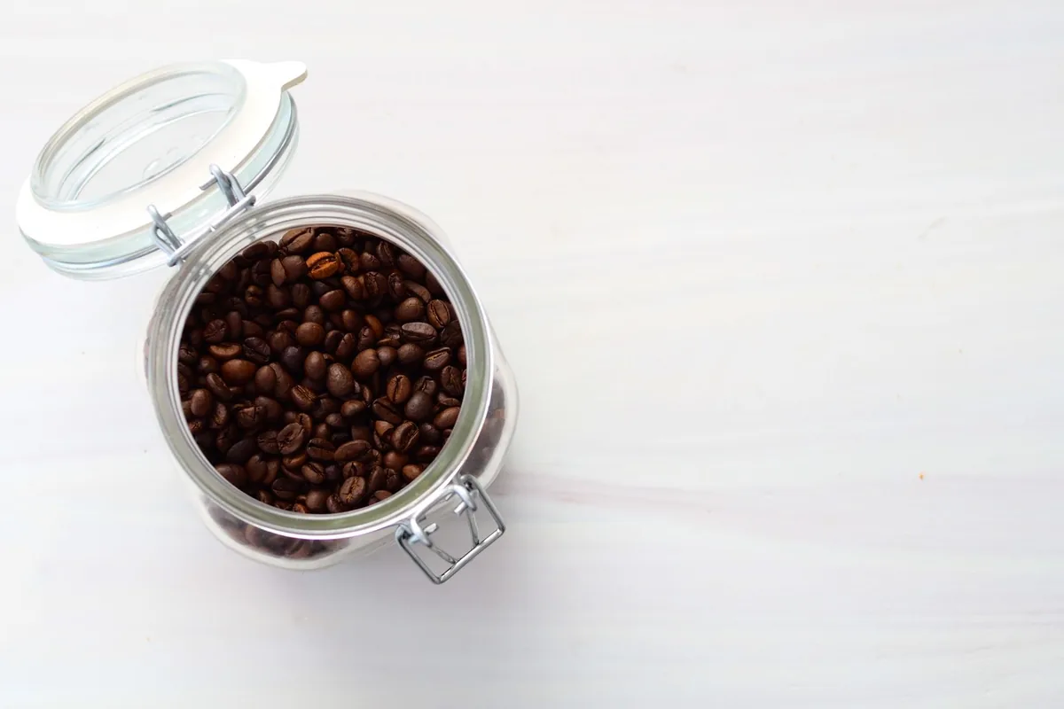 A clamp-lid glass jar of coffee beans seen from above