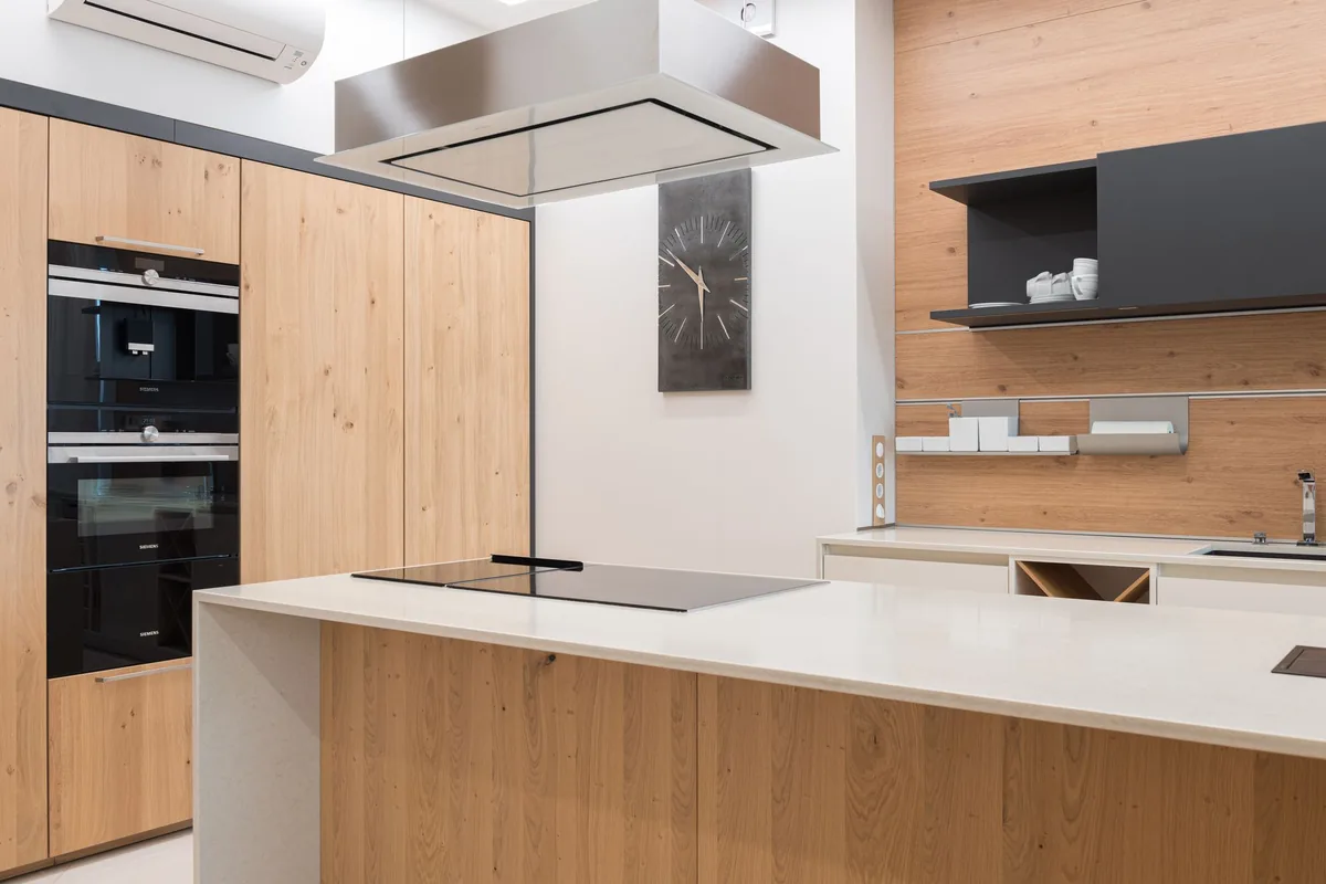 A modern kitchen with built-in ovens and a flush cooktop