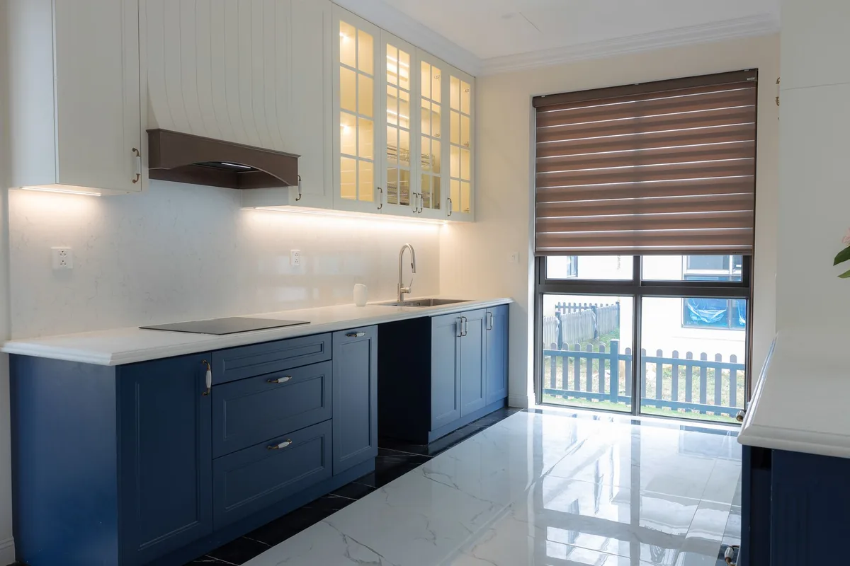 A clean, bright kitchen worktop with white wall cabinets mounted above it