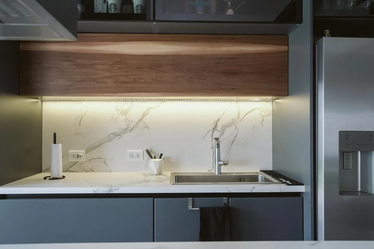 A clean kitchen counter with small appliances set beneath pale wall cabinets