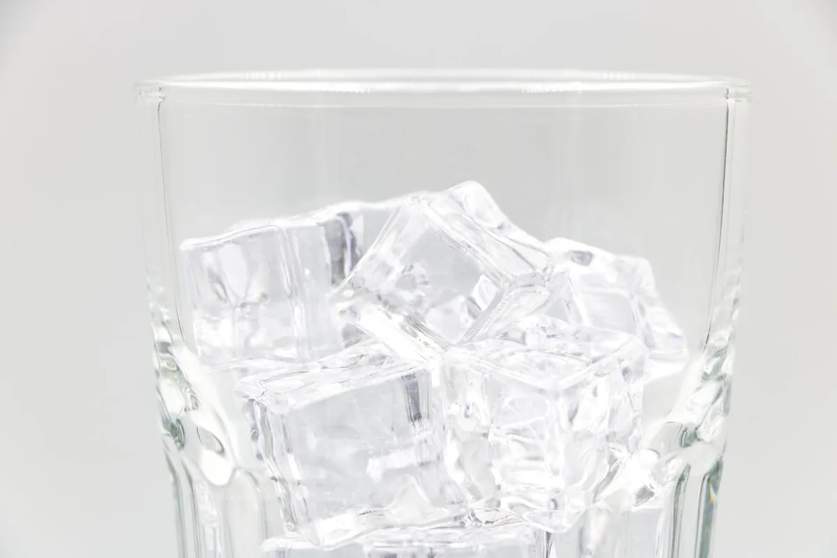 A close view of clear ice cubes piled together on a light surface