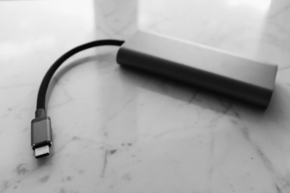 A USB-C adapter with a short cable on a marble surface