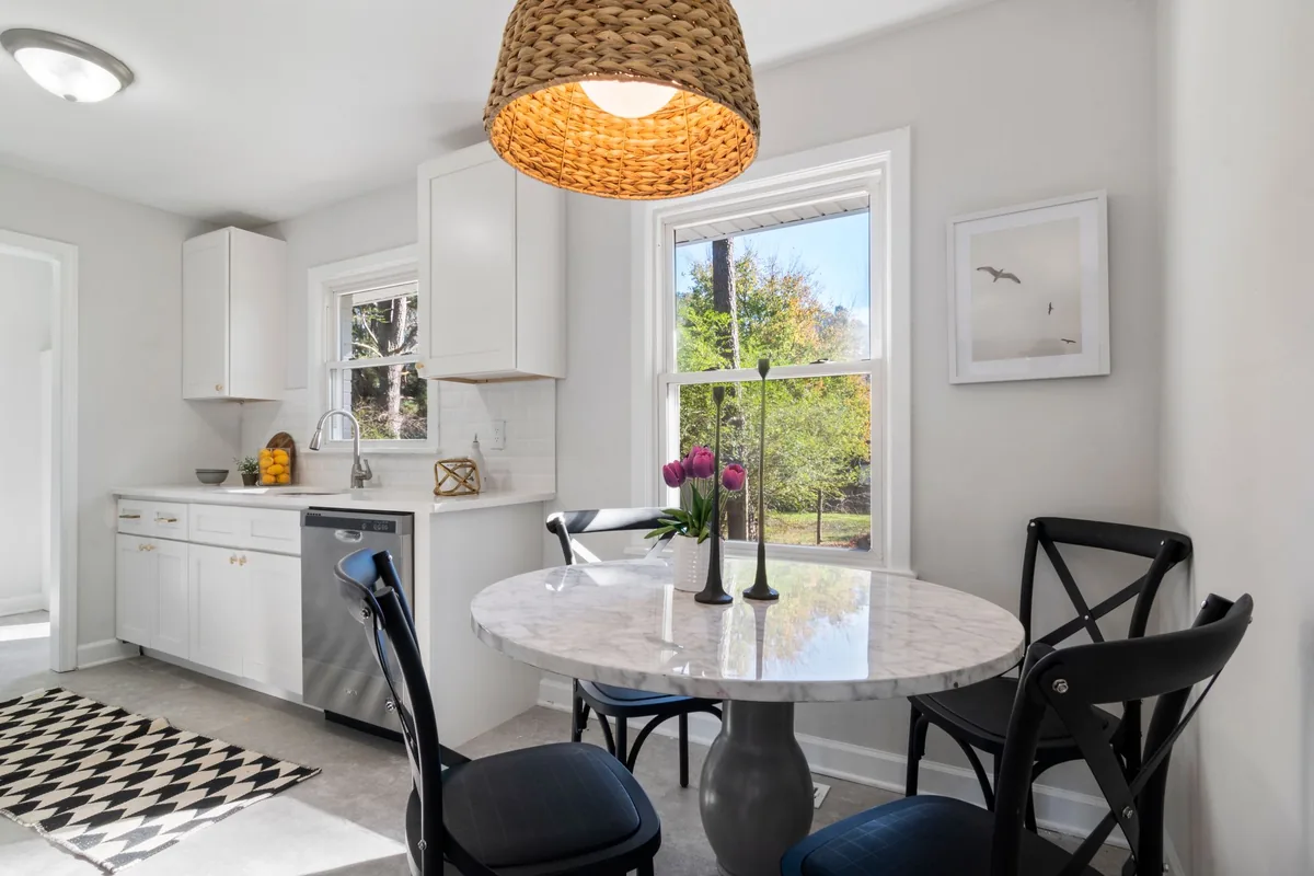 A compact bright kitchen with white cabinets and a stainless steel sink