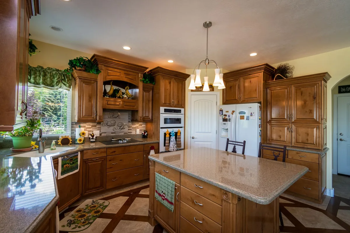 A wood-cabinet kitchen with a towel hanging from the island