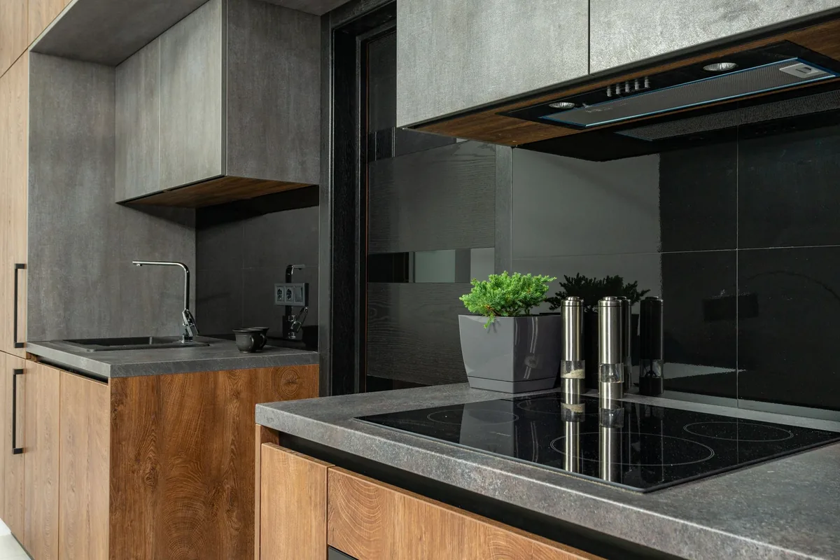 A grey kitchen with an induction cooktop set into a stone counter