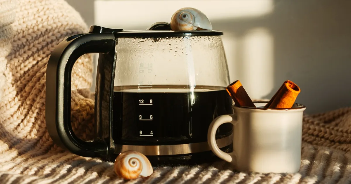 A drip coffee maker with a glass carafe of coffee