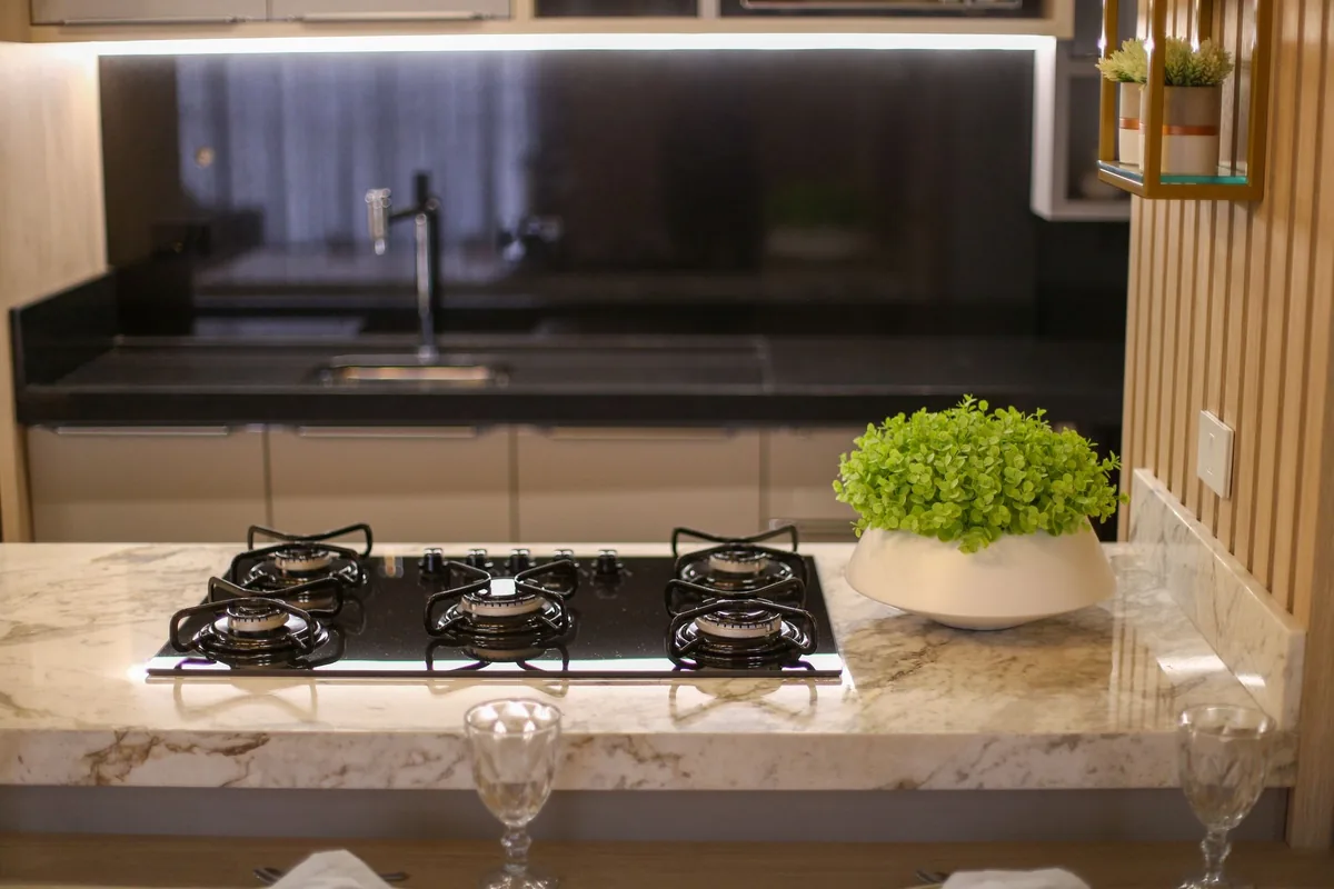 A gas cooktop set into a stone island