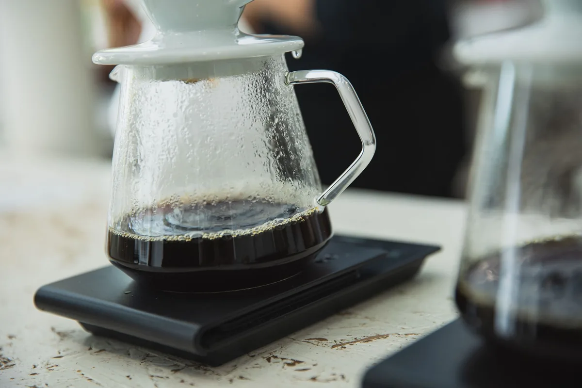 A glass carafe of coffee on a black digital scale