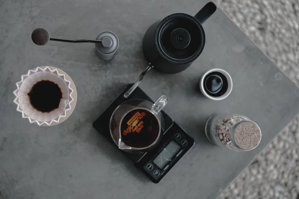 A kettle, dripper and scale seen from above on a grey counter