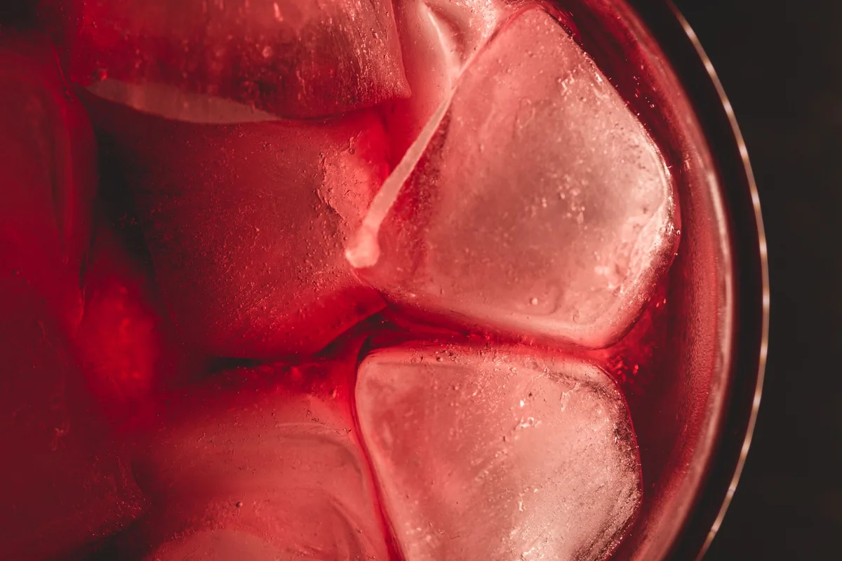 Ice cubes in a pink drink, seen close up