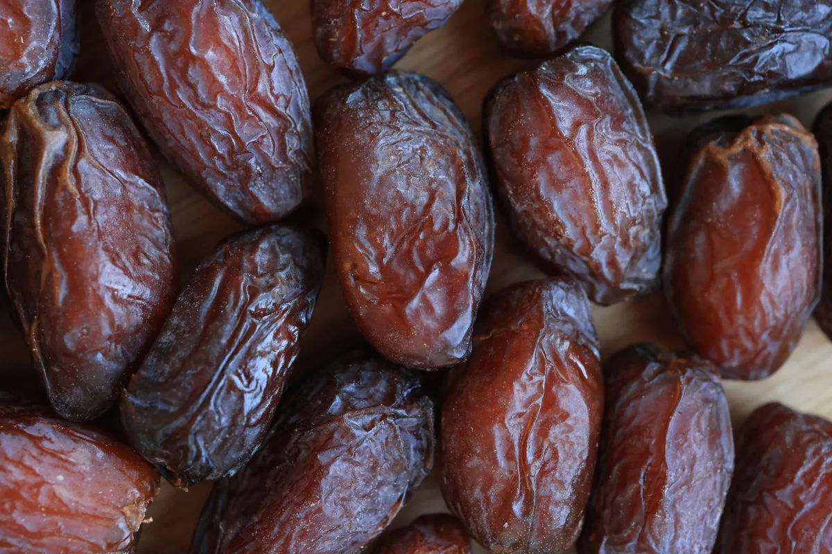 A plate of soft brown dates on a pale kitchen table