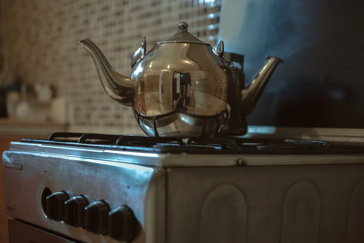 A steel kettle on an old gas range