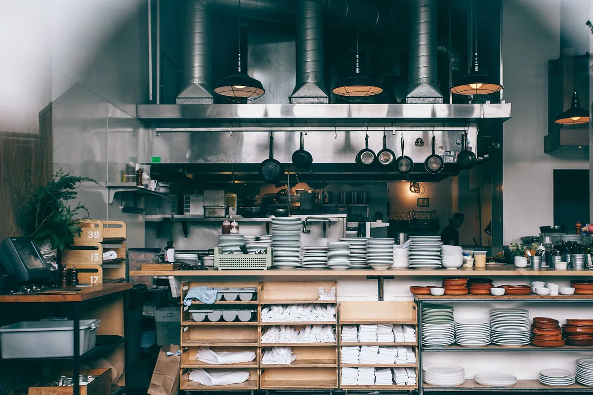 A restaurant kitchen with plate shelves and steel counters