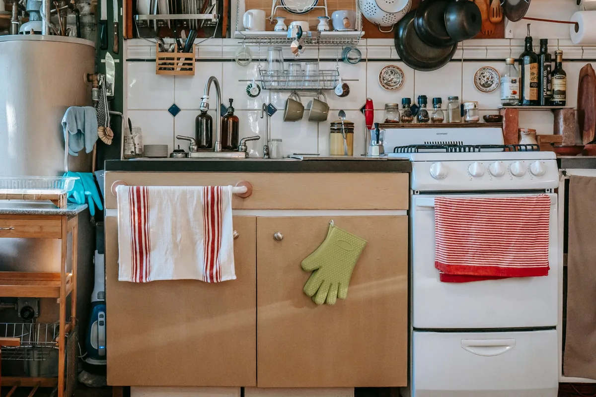 A home kitchen with a white stove and hanging utensils