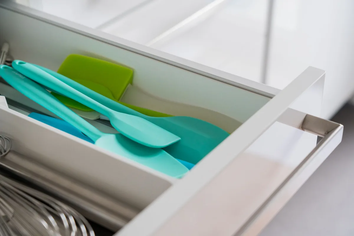 A set of silicone spatulas and spoons laid out on a light worktop