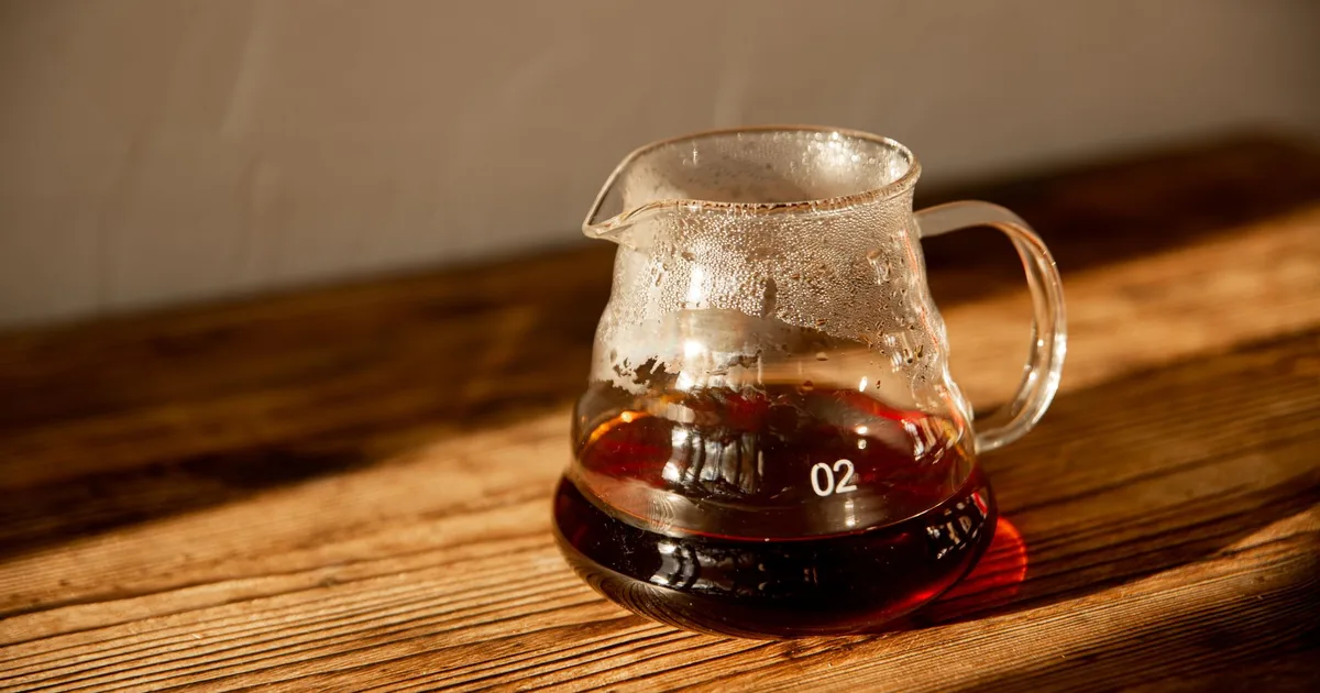 A small glass coffee server on a wooden table