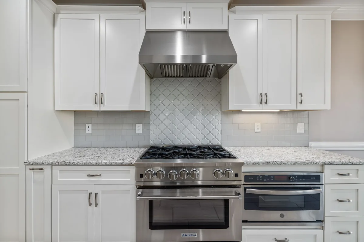 A stainless steel extractor hood mounted above a clean kitchen hob